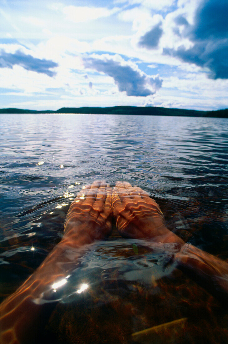 Mann schwimmt durch See, Nahaufnahme Hände, Västergötland, Schweden