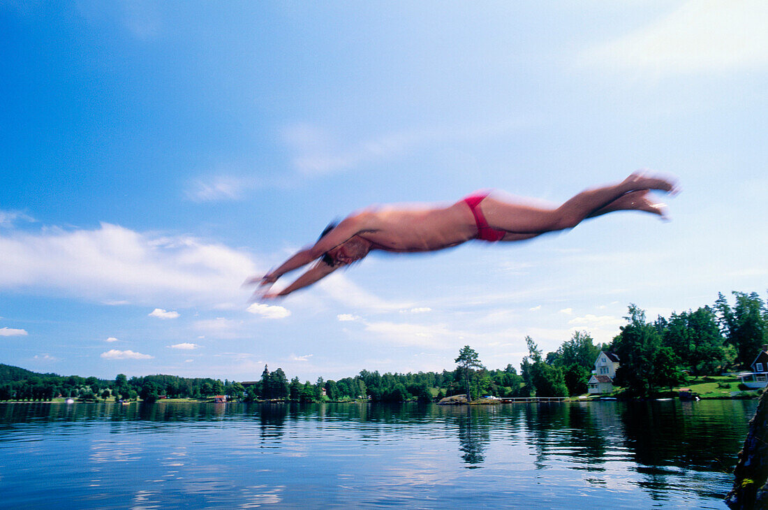 Mann springt in einen See, Östergötland, Schweden