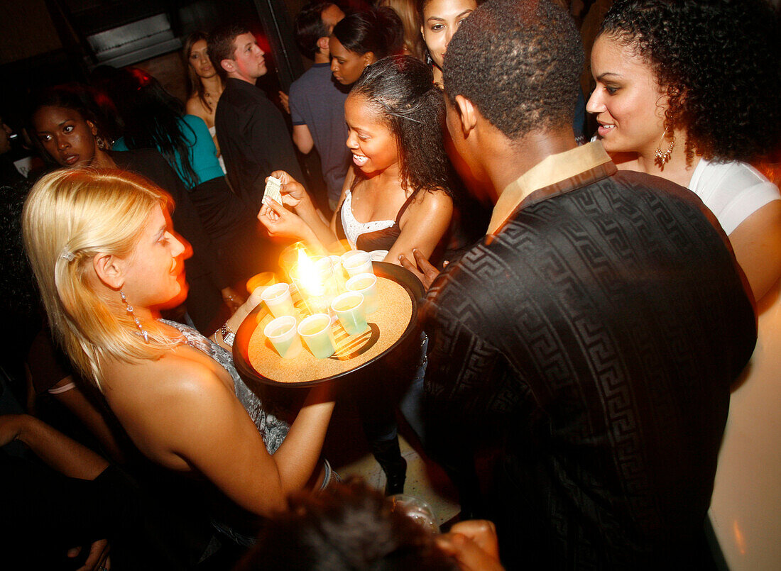 A group of people partying and having drinks in a nightclub Club FIve, Washington DC, United States, USA