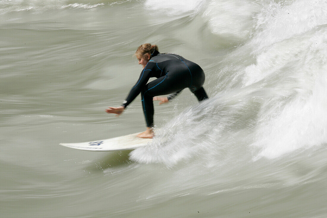 A surfer surfing on the waves of the Inn near Crazy EDDY in Silz, Haiming, Tyrol, Austria