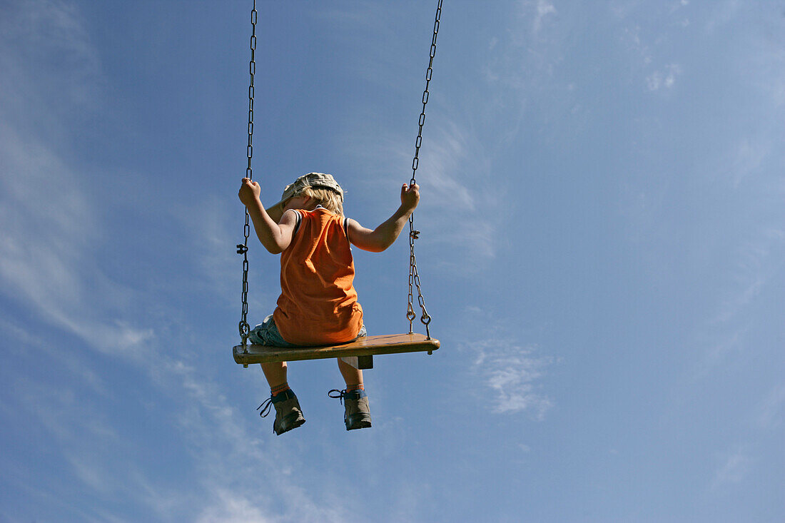 Boy (5-6 years) on a swing
