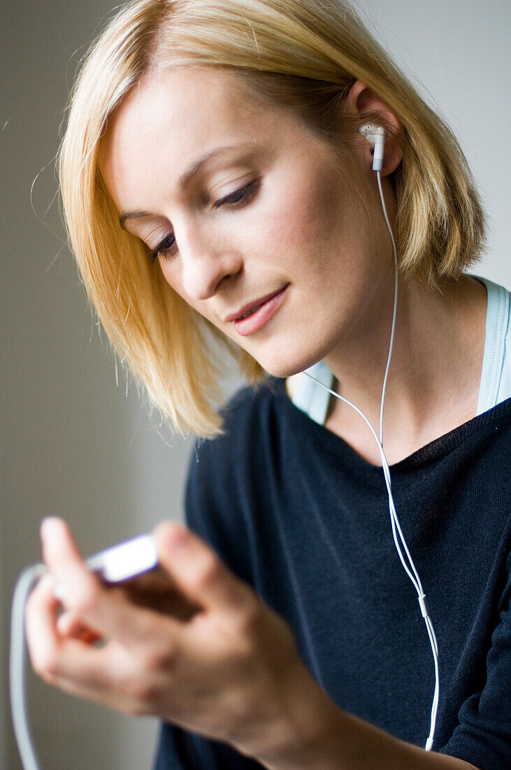 Young woman listening to music about earphones