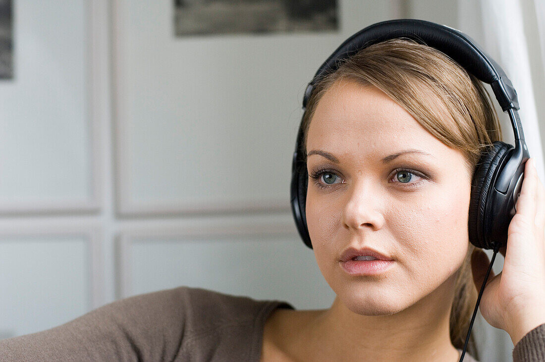 Young woman listening to music about earphones