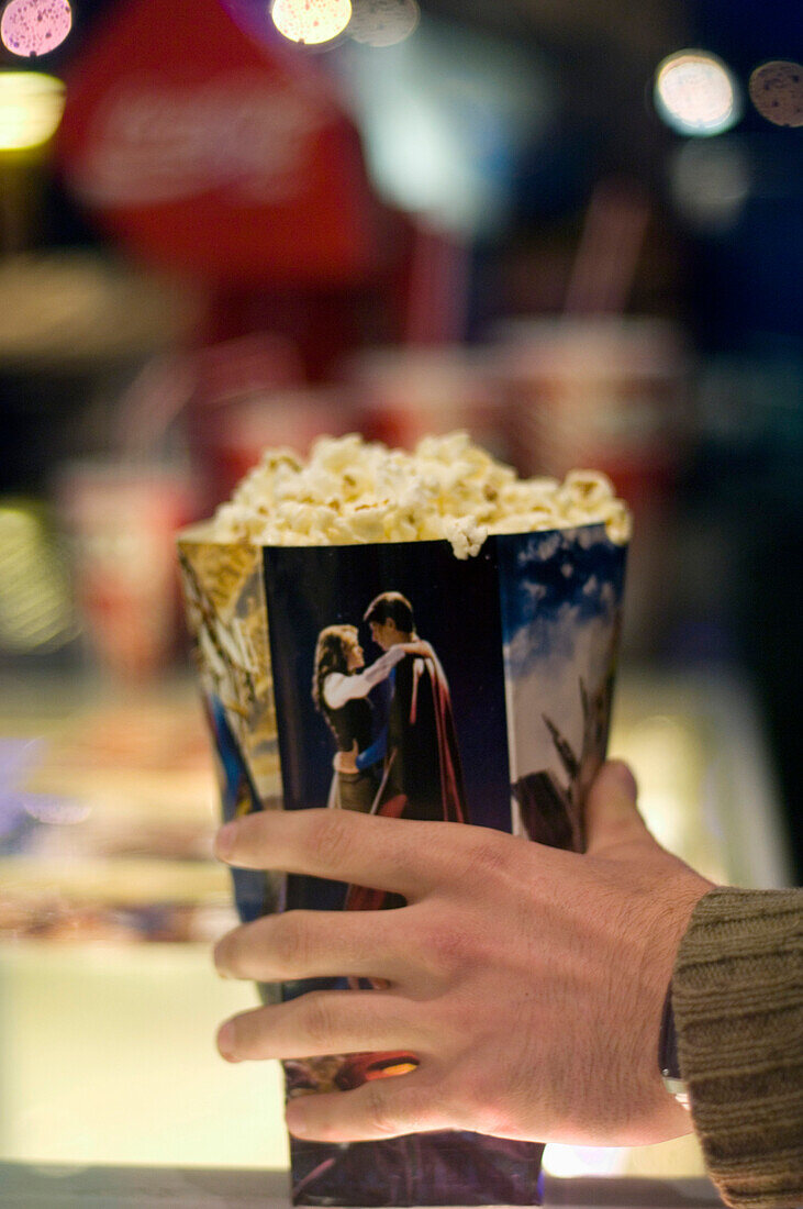 Male hand holding a popcorn carton