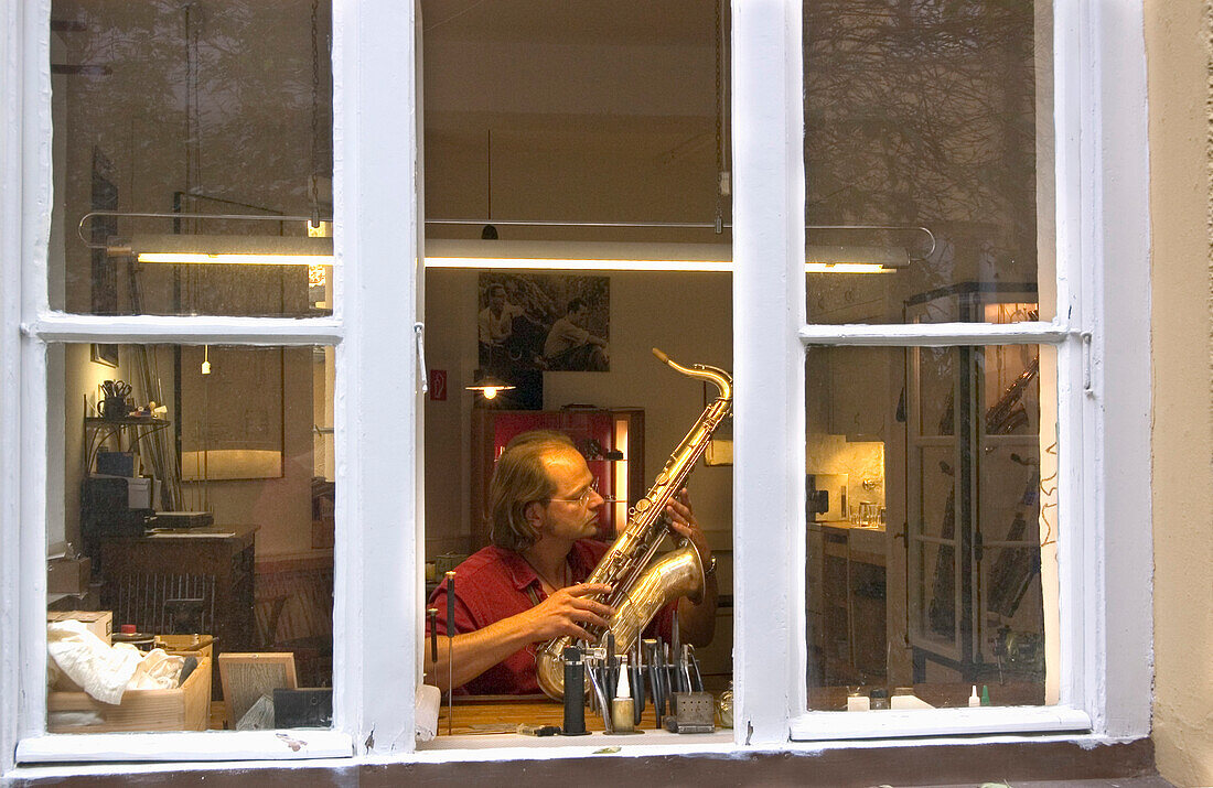 Mann repariert Saxophon, München, Bayern, Deutschland