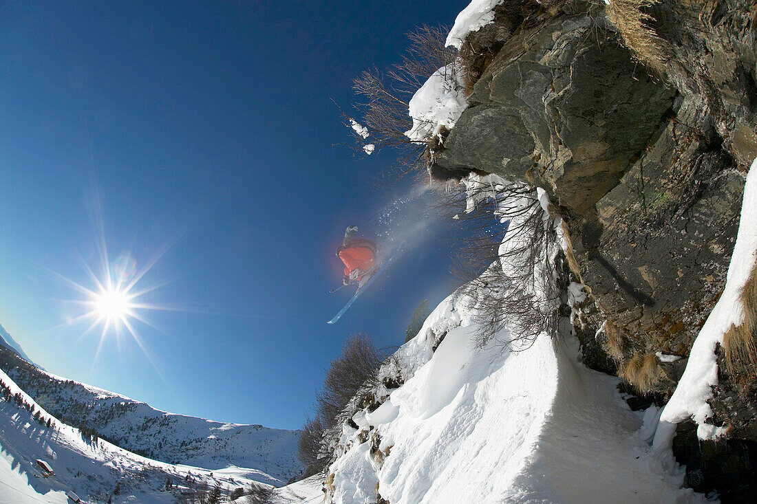 Skier jumping over rock, Falkertsee, Carinthia, Austria