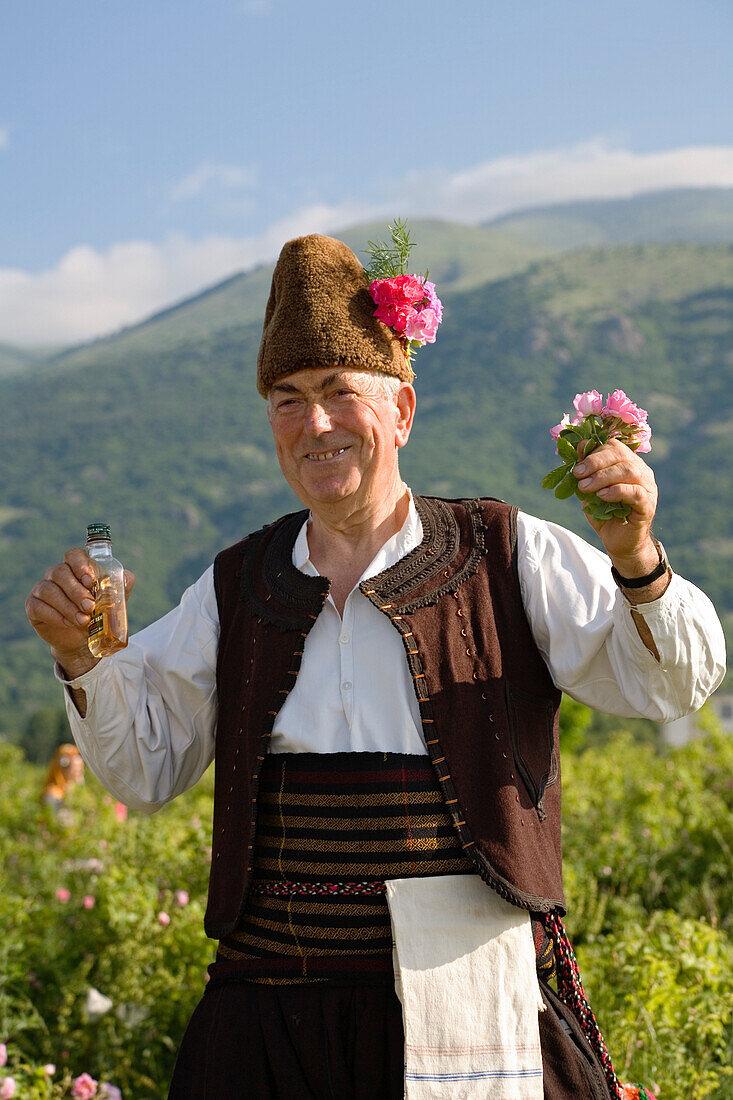 Bulgarian man in traditional costume with rose oil and roses, Rose Festival, Karlovo, Bulgaria, Europe