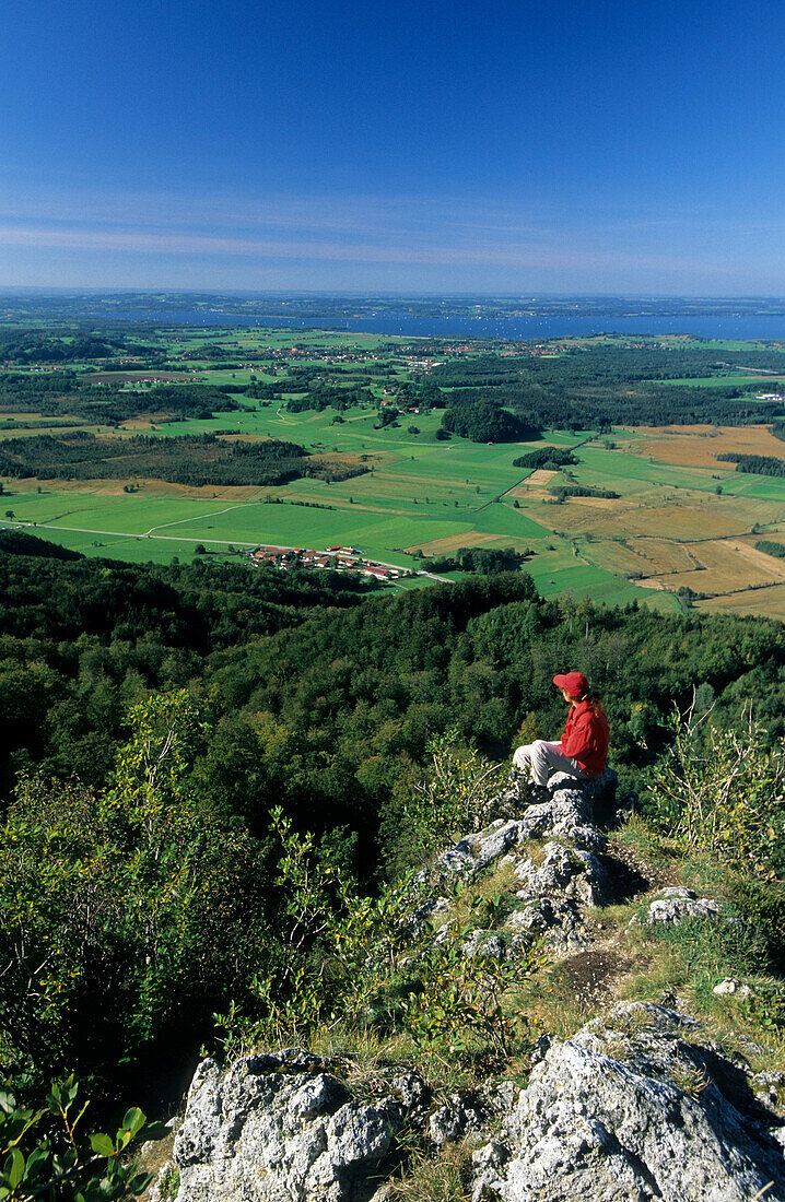 hiker beneath Hochfelln with view to lake Chiemsee and swamps, Chiemgau, Upper Bavaria, Bavaria, Germany