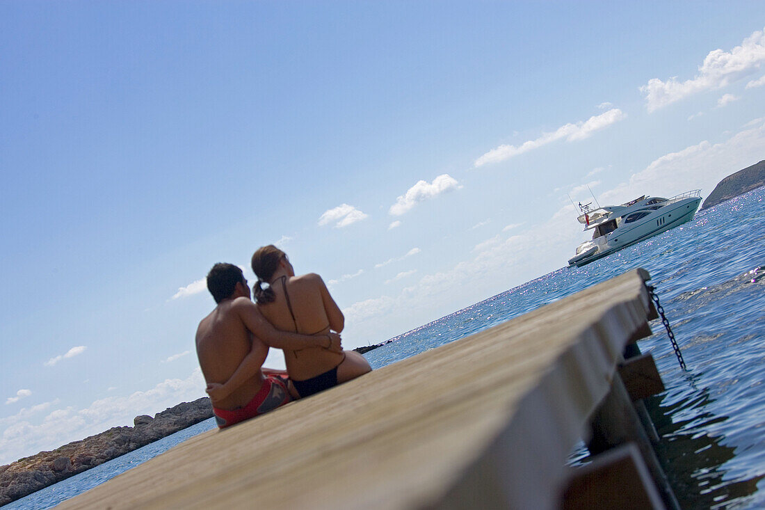 Young couple on a jetty on the waterfront, Punta Negra, Majorca, Balearic Islands, Spain, Europe