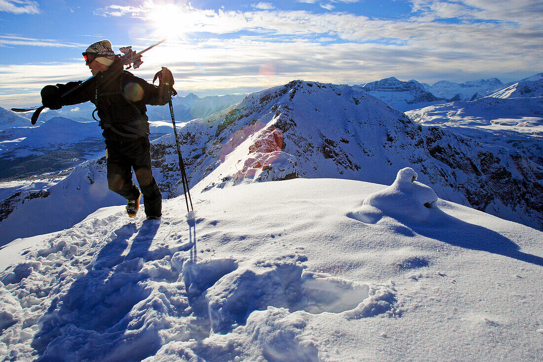 Banff, Sunshine, Kanada, Ein junger Mann trägt seine Skis zur extremen Skisabfahrt Delirium Dive im Skigebiet Sunshine, Alberta, Rocky Mountains, Kanada, Nord Amerika, MR