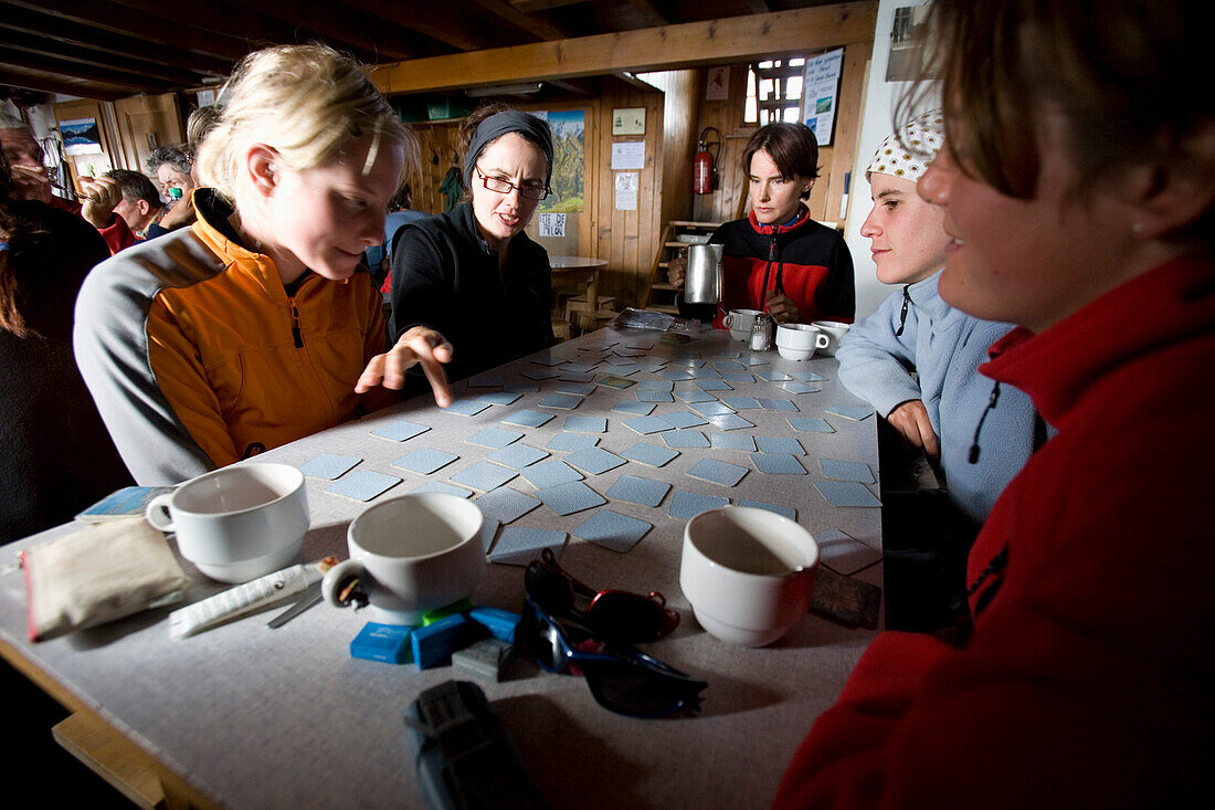 Group of young woman playing memory, Tracuit hut, Pennine Alps, canton of Valais, Switzerland, MR