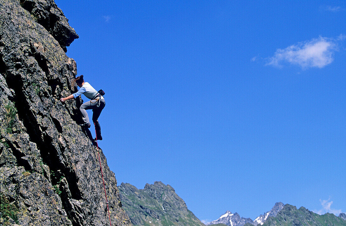 Junge Frau klettert an Felswand, Urner Alpen, Kanton Uri, Schweiz, MR