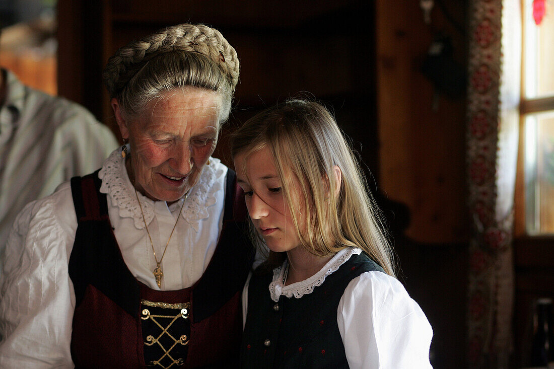 Senenrin spricht mit ihrer Enkelin, beide im Dirndl in der Maurachalm, Nationalpark Hohe Tauern, Salzburger Land Österreich