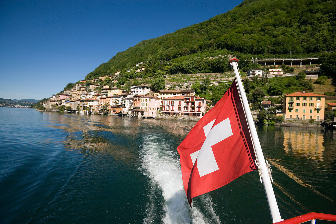 Motorboat on Lake Lugano leaving Gandria, a picturesque village at mountainside of mount Monte Bre, Ticino, Switzerland