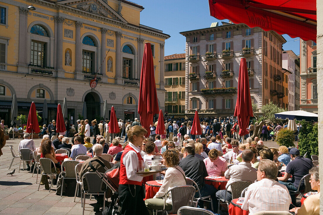 People sitting in a pavement cafea Piazza della Riforma, Lugano, Lake Lugano, Ticino, Switzerland