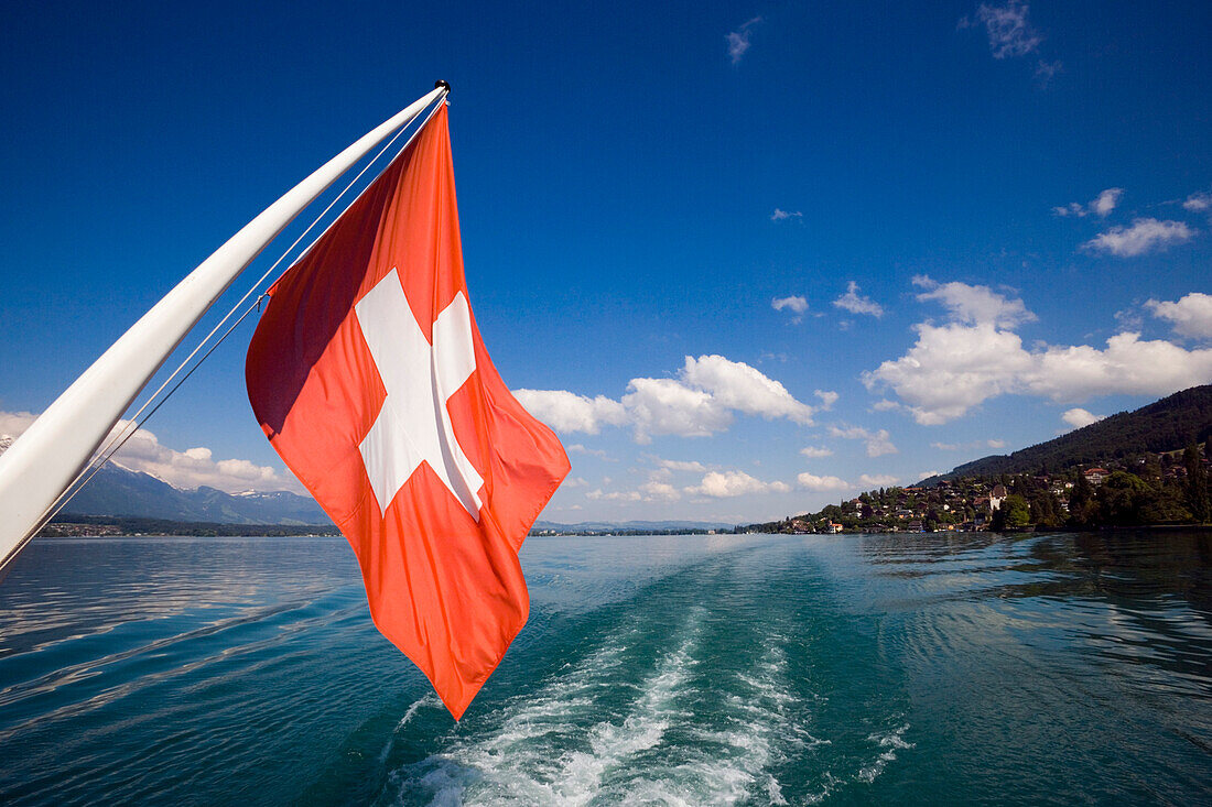 Swiss flag at the stern of a ship on Lake Thun, Bernese Oberland, Canton of Bern, Switzerland