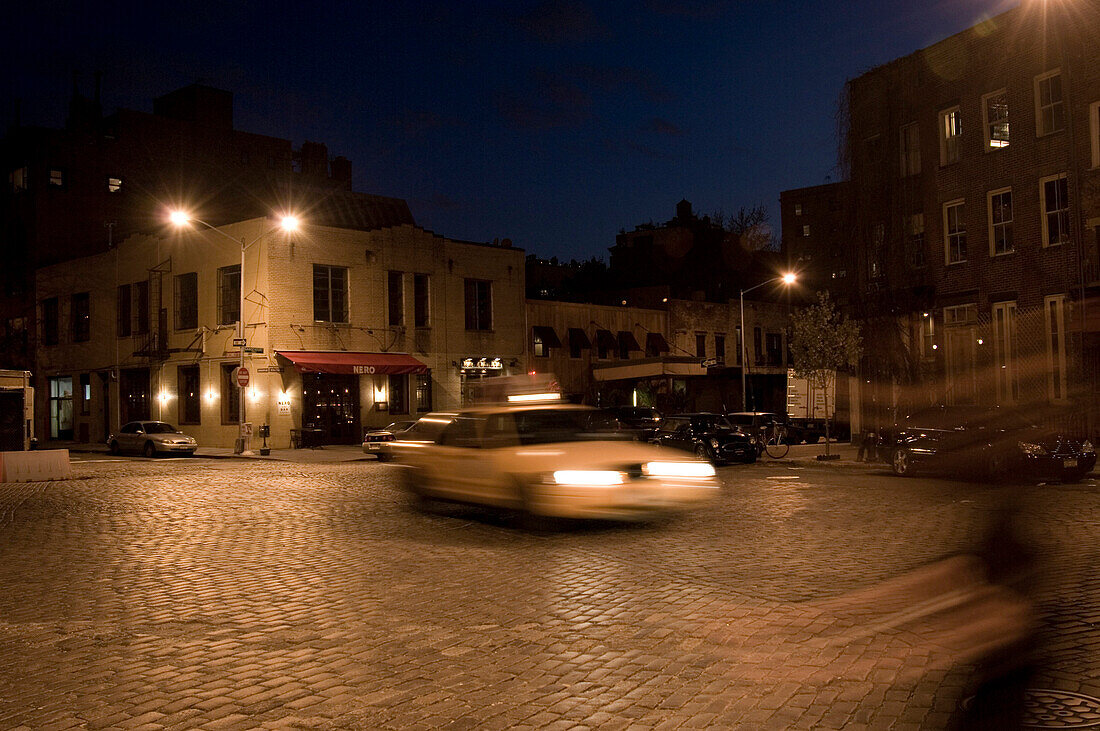 Ein Taxi fährt bei Nacht durch die Strassen, Meatpacking District, Manhattan, New York, USA