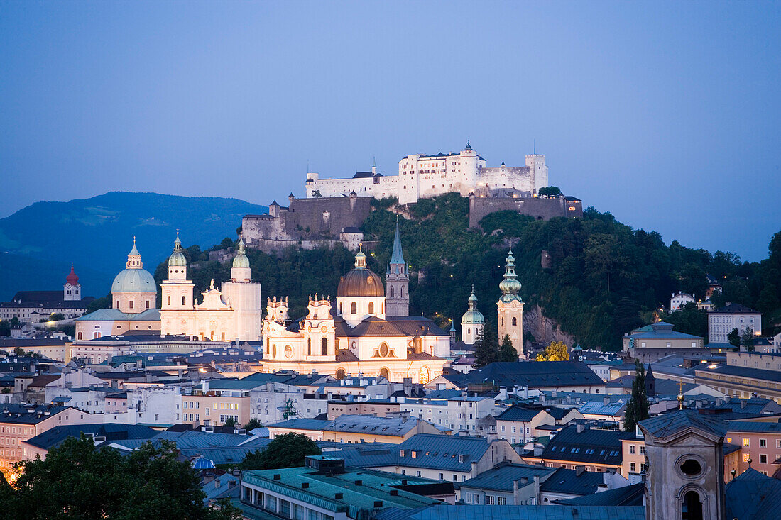 View over Salzburg with Hohensalzburg Fortress, the largest fully preserved fortress in central Europe, Salzburg Cathedral, Franciscan Church, St. Peter's Archabbey and Collegiate Church at night, Salzburg, Austria. Since 1996 the historic centre of the c