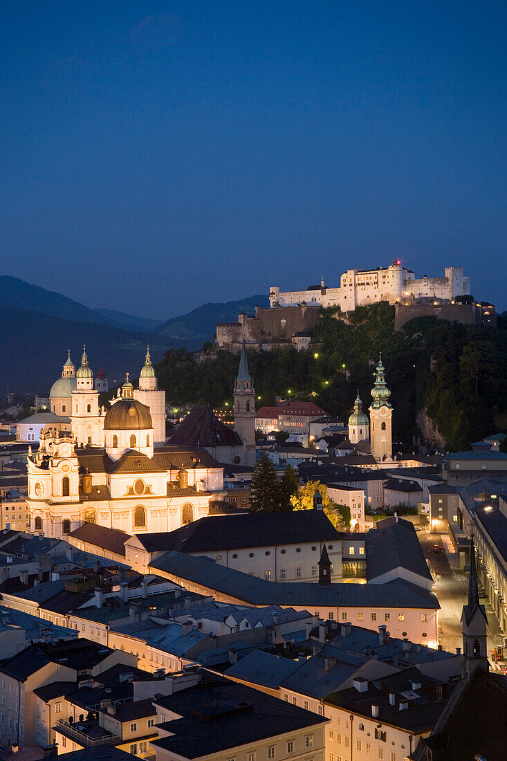 View over illuminated old town with Hohensalzburg Fortress, the largest fully preserved fortress in central Europe, Salzburg Cathedral, Franciscan Church, St. Peter's Archabbey and Collegiate Church at night, Salzburg, Austria. Since 1996 the historic cen