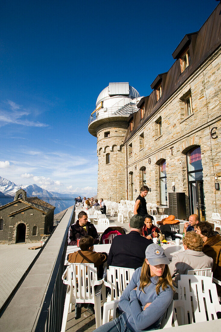 People sitting on terrace of the Kulmhotel restaurant, the highest hotel in the Swiss Alps (3100 m) at Gornergrat, Zermatt, Valais, Switzerland