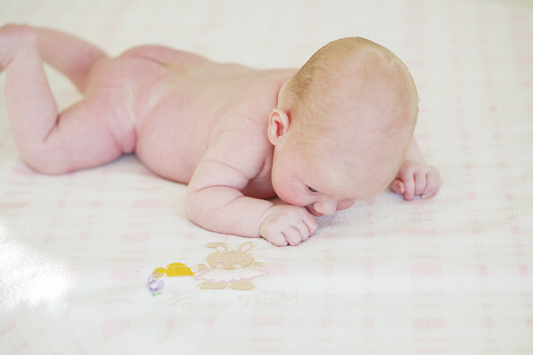 Baby liegt auf Decke