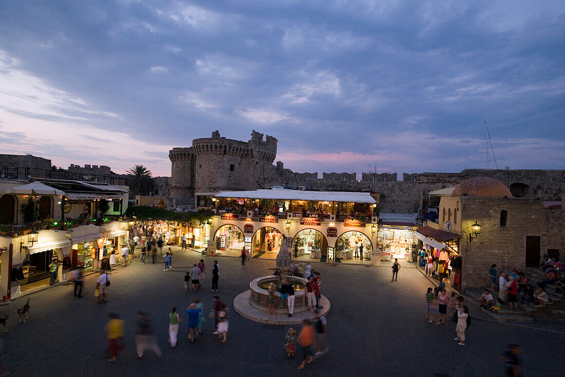 View over busy Platia Ippokratou with Thalassini Gate in background in the evening, Rhodes Town, Rhodes, Greece, (Since 1988 part of the UNESCO World Heritage Site)