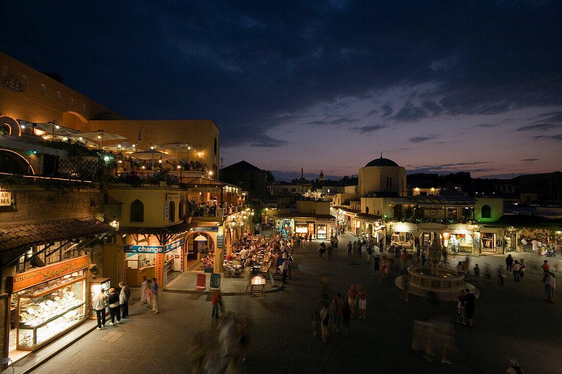 View over Platia Ippokratou with pavement cafes and shops in the evening, Rhodes Town, Rhodes, Greece, (Since 1988 part of the UNESCO World Heritage Site)