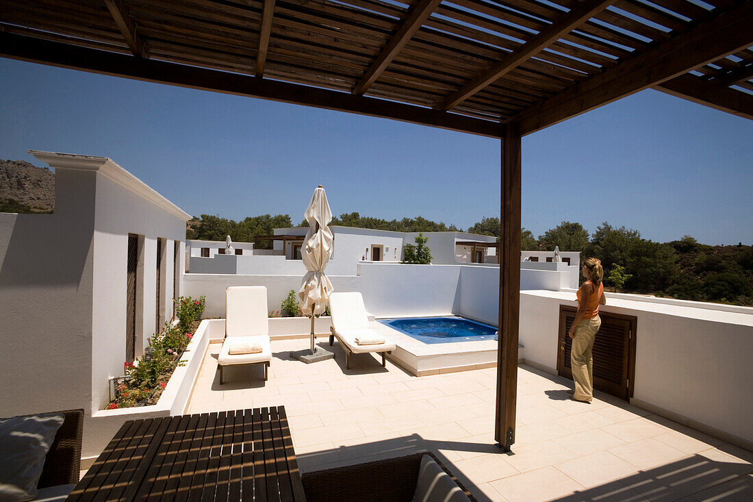 Young woman standing on a terrace of a Hotel, Lardos, Rhodes, Greece