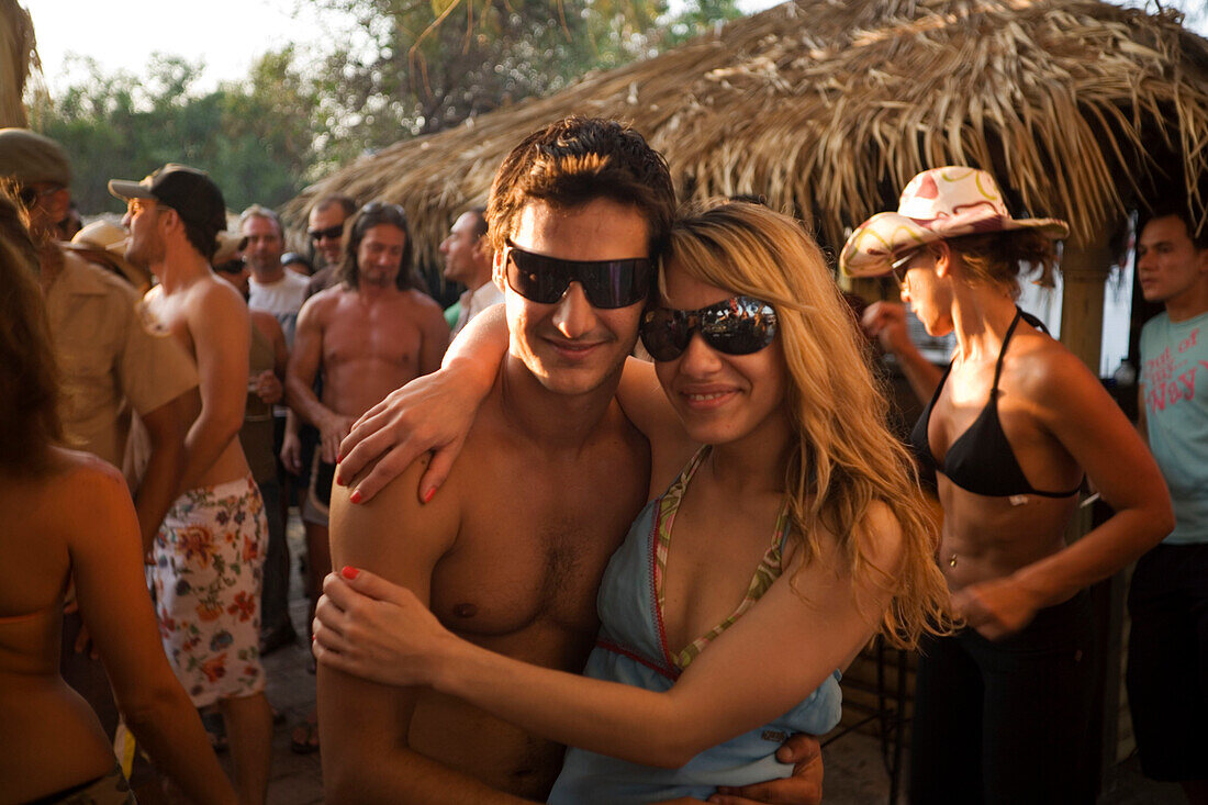 Portrait of young couple embracing each other smiling at camera, sunday party at Sundance Beach Bar, Gennadi beach, Gennadi, Rhodes, Greece