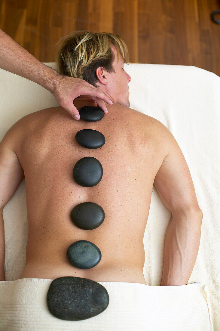 Man having LaStone therapy in a spa hotel, Germany, MR