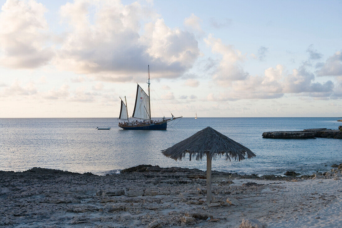 Strandschirm und Segelboot am Malmok Beach, Aruba, ABC-Inseln, Niederländische Antillen, Karibik