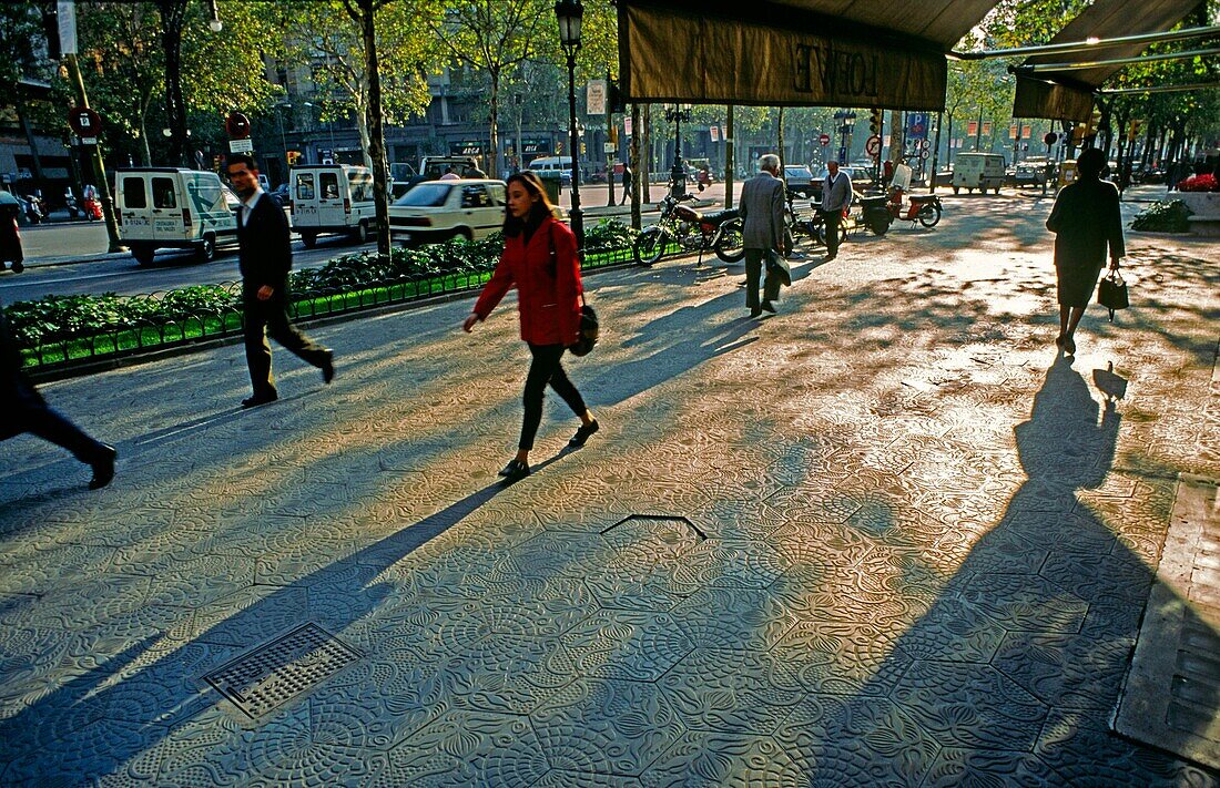 Spanien,Passeig gracia,Bürgersteig mit Verzierungen im Gegenlicht,Passanten