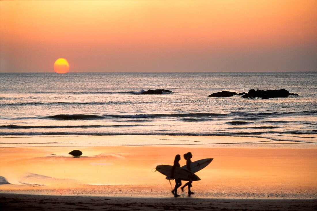 Surfer on Playa Coco at sunset, Costa Rica