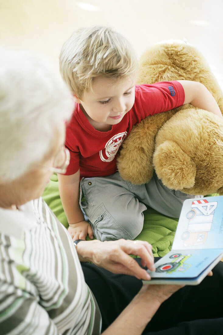 Grandmother and grandchild reading a book together