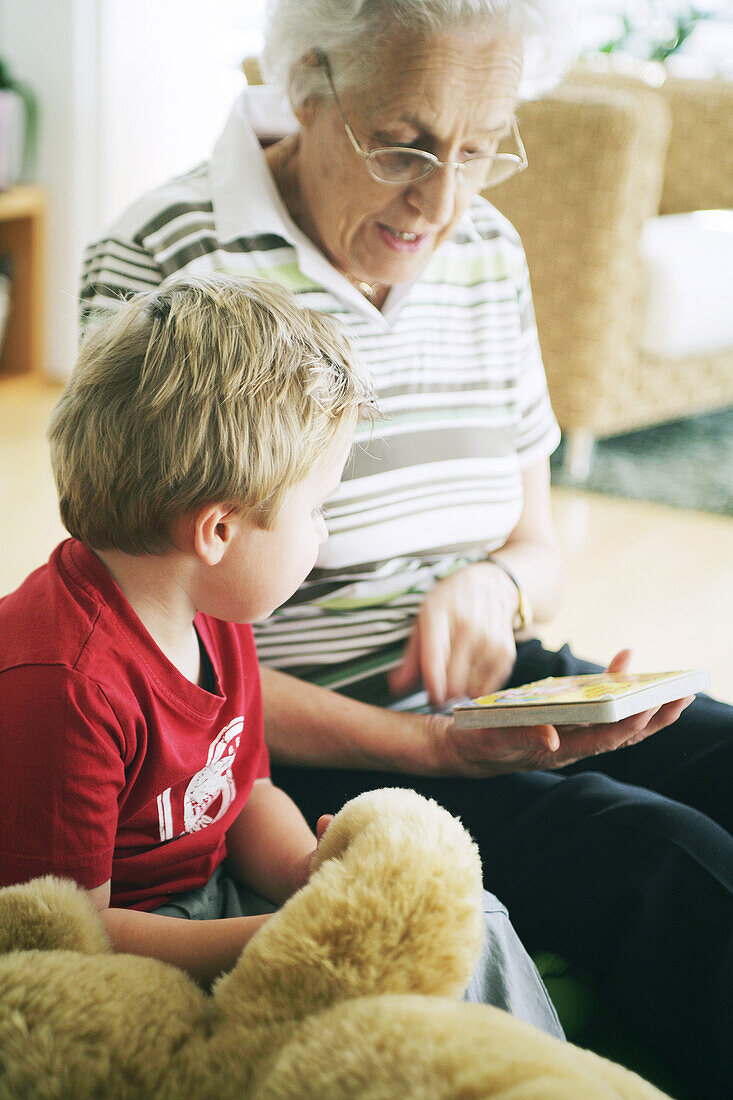 Oma und Kind lesen Buch, Kind, Familie, Generationen