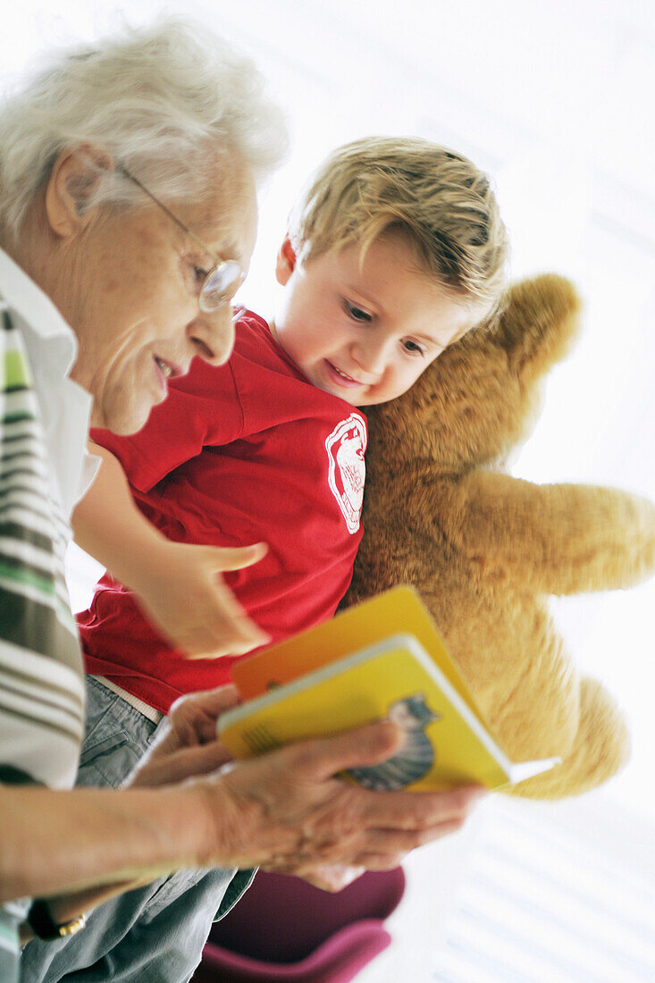 Oma und Kind lesen Buch, Kind, Familie, Generationen