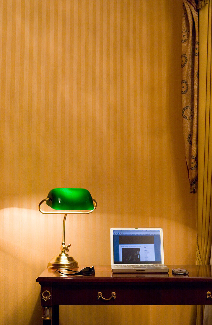 Lapotp, mobile phone and sunglasses on table with desk lamp, Weimar, Thuringia, Germany