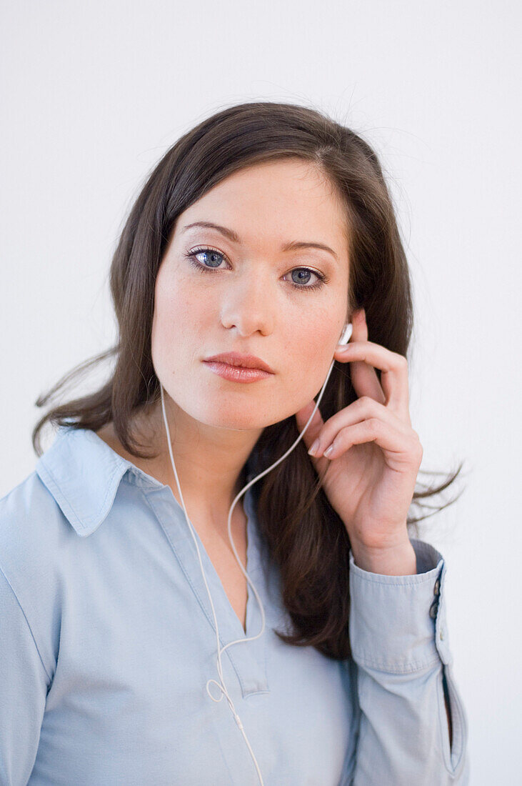 Young woman listening to music about earphones