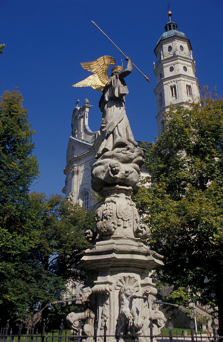 Statue in front of abbey church under blue sky, Neresheim, Baden-Wuerttemberg, Germany, Europe