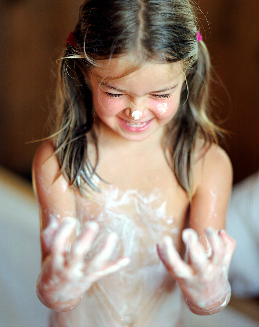 Wellness for children, girl has covered herself with a natural body mixture of honey, oil and cream, Wellness Hotel, Germany