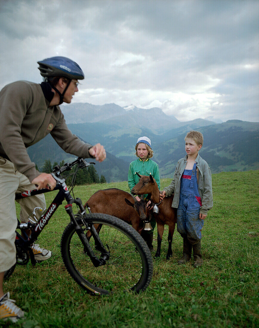 Mountainbiker, Kinder hüten Ziegen, über dem Simmental, Berner Alpen, Kanton Bern,Schweiz