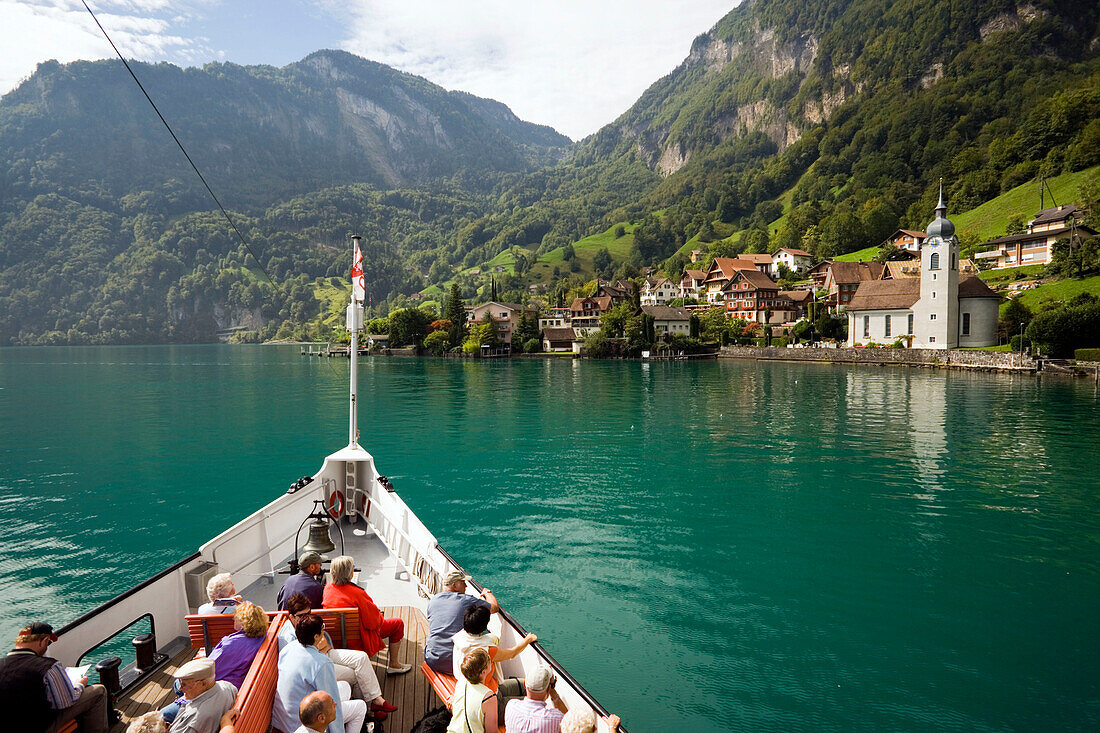 Passengers sitting on deck of a paddle wheel steamer, arriving Bauen, Lake Urnersee, part of Lake Lucerne, Bauen, Canton of Uri, Switzerland