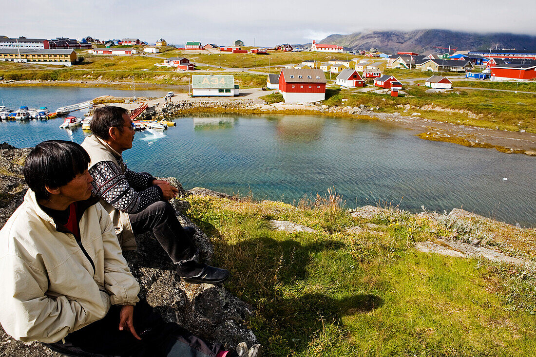 Two Inuit enjoy the view over Narsaq, South Greenland