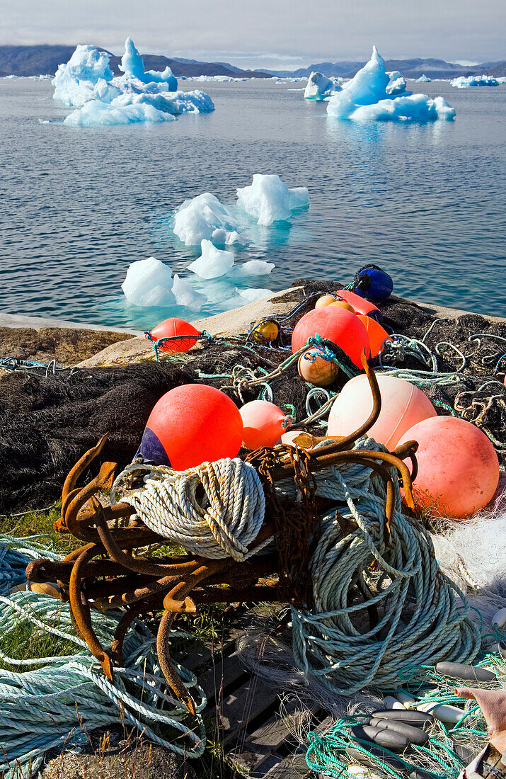 Eisberge und Fischerutensilien vor der Küste der Stadt Narsaq, Südgrönland