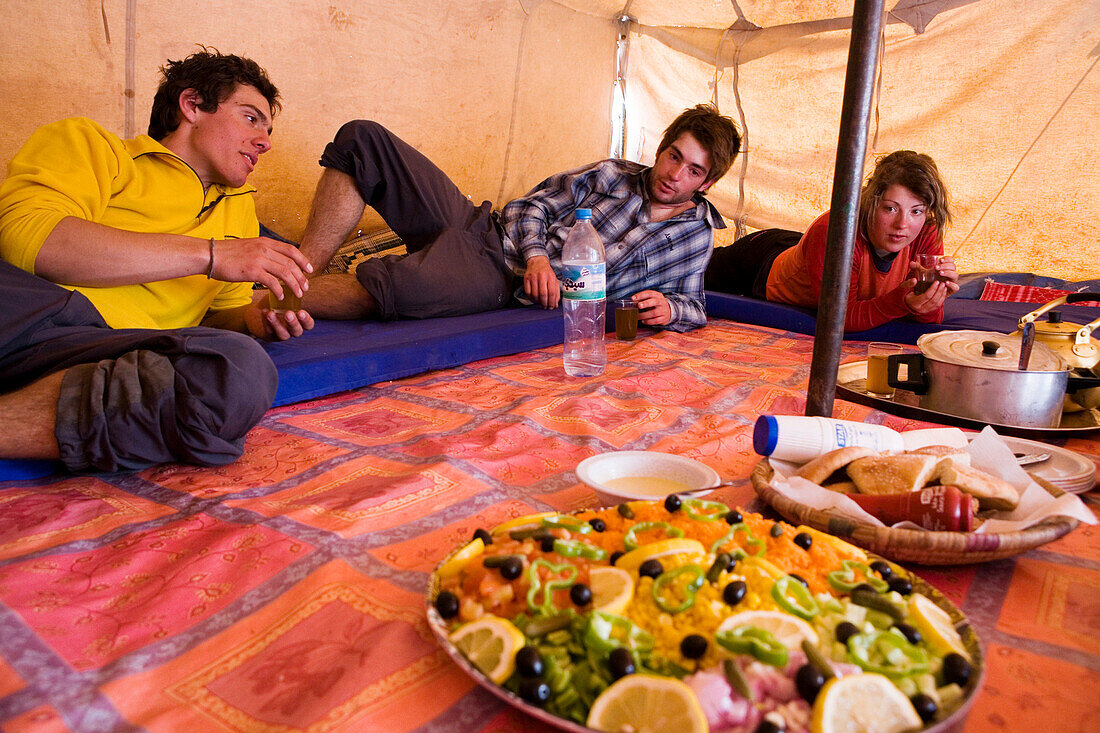 Trekker vor ihrem Mittagessen in einem Berberzelt, Marokko, Hoher Atlas, Toubkal Region, Nord Afrika