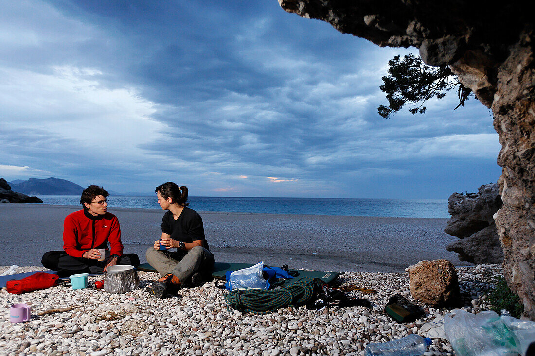 Adventurous trekking Il Sentiereo Selvaggio Blu, Sardinia, Golfo di Orosei, Italy. A young men and a young woman bivouac on the beach Cala Sisine, MR