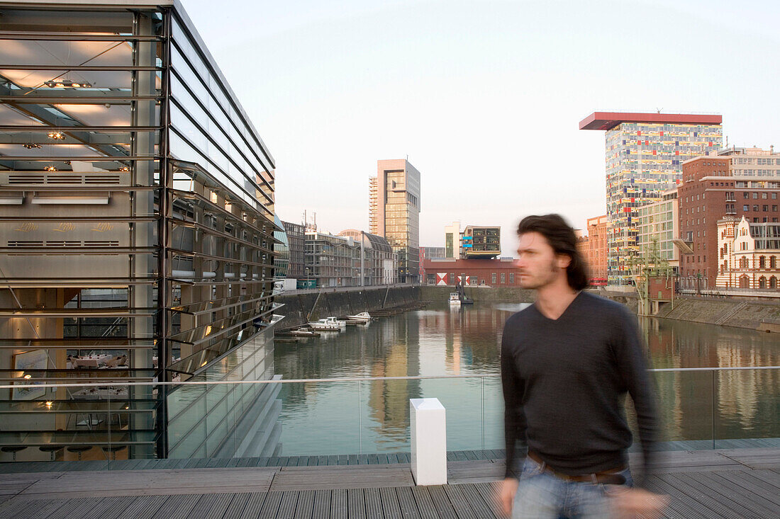 Vorbeigehender Mann im Düsseldorfer Medienhafen, moderne Architektur, Nordrhein-Westfalen, Landeshauptstadt von NRW, Deutschland