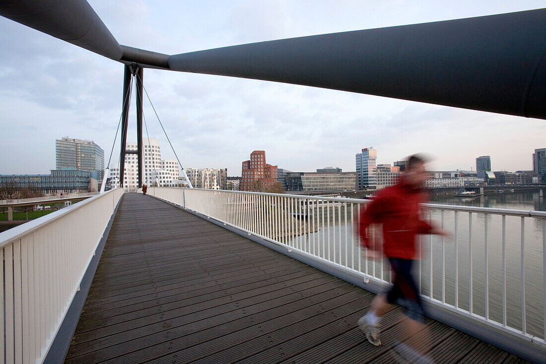 A person jogging over the footbridge, Media Harbour Düsseldorf, state capital of NRW, North-Rhine-Westphalia, Germany