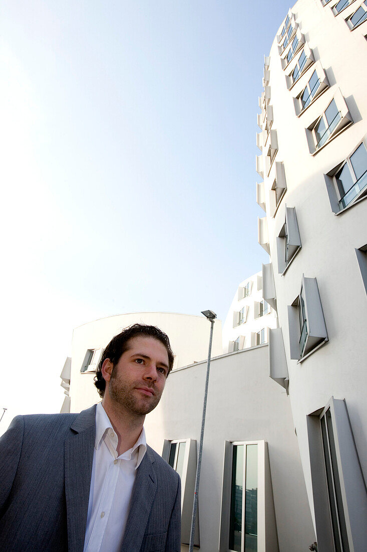 Junger Geschäftsmann vor Neuer Zollhof, Architektur von Frank O.Gehry, Medienhafen in Düsseldorf, Nordrhein-Westfalen, Landeshauptstadt in NRW, Deutschland