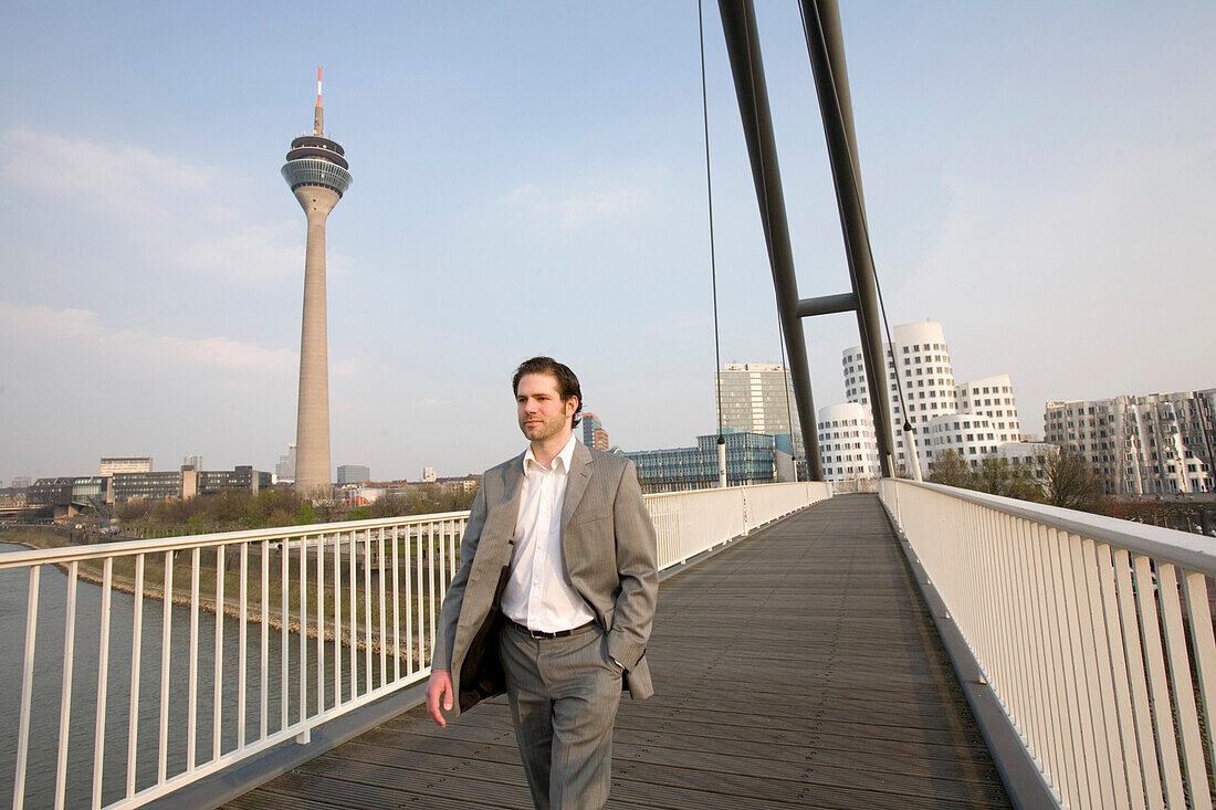 Mann geht über Fußgängerbrücke, Medienhafen in Düsseldorf, Zollhafen, Nordrhein-Westfalen, Landeshauptstadt in NRW, Deutschland
